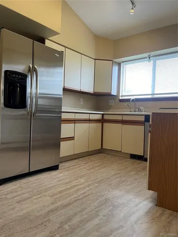 a kitchen with stainless steel appliances granite countertop a refrigerator a sink and a stove