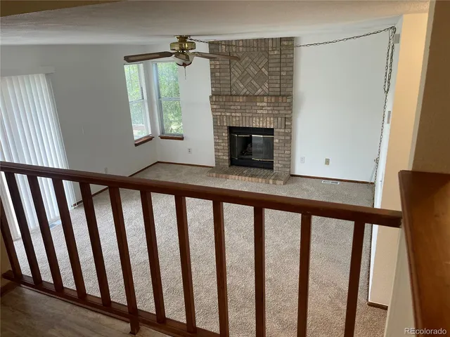 a view of open kitchen with staircase and fireplace