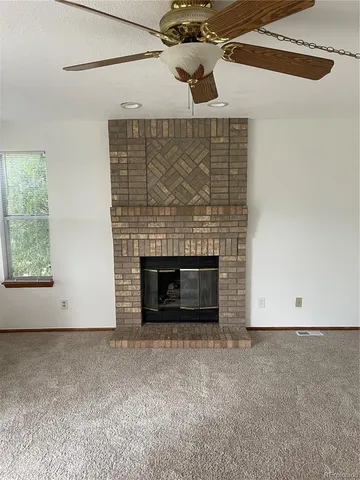 an empty room with a fireplace and fan