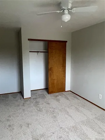 an empty room with fan and entrance