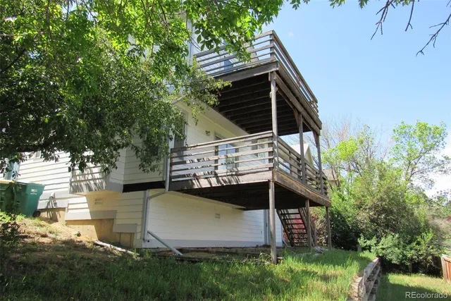 a view of house with backyard and trees