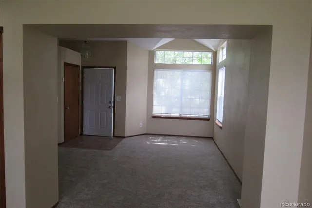 an empty room with windows and closet