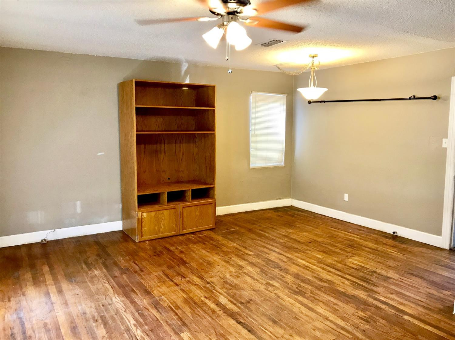 3016 30th Street Lubbock, TX 79410 - Photo 2 of 8 wooden floor in an empty room with a window