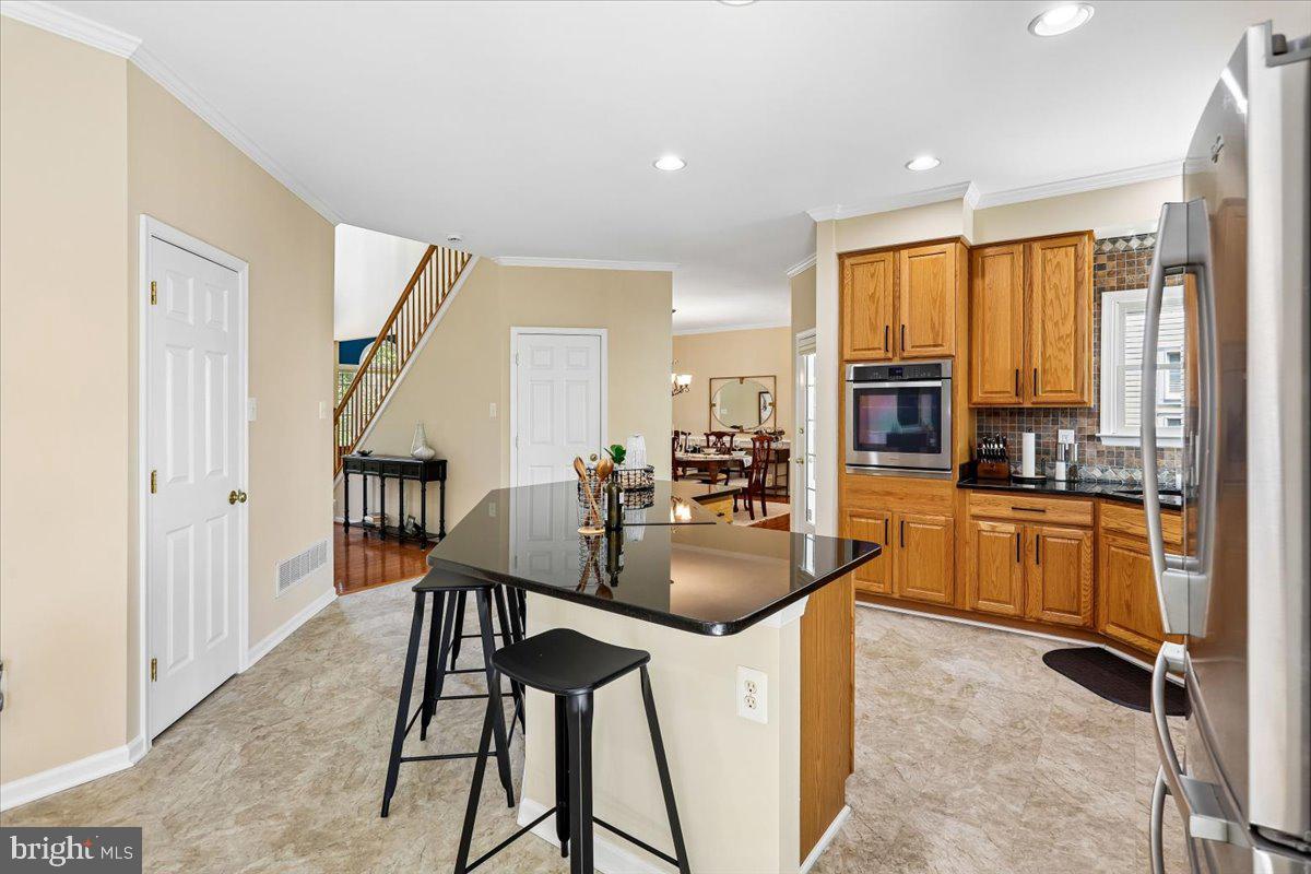 9909 Midsummer Snow Lane Laurel, MD 20723 - Photo 14 of 81 a kitchen with sink refrigerator dining table and chairs