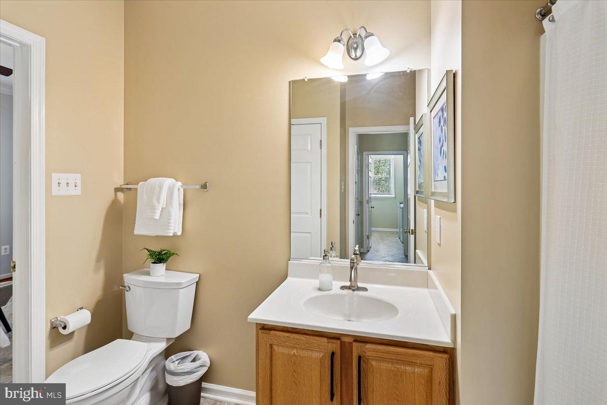 9909 Midsummer Snow Lane Laurel, MD 20723 - Photo 26 of 81 a bathroom with a granite countertop sink a toilet and a mirror