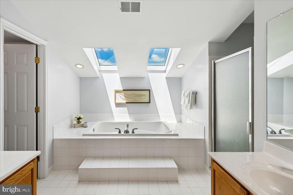 9909 Midsummer Snow Lane Laurel, MD 20723 - Photo 32 of 81 a bathroom with a tub sink and mirror