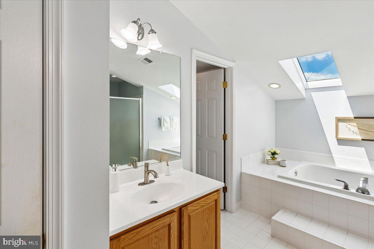 9909 Midsummer Snow Lane Laurel, MD 20723 - Photo 33 of 81 a bathroom with a sink vanity tub and a mirror