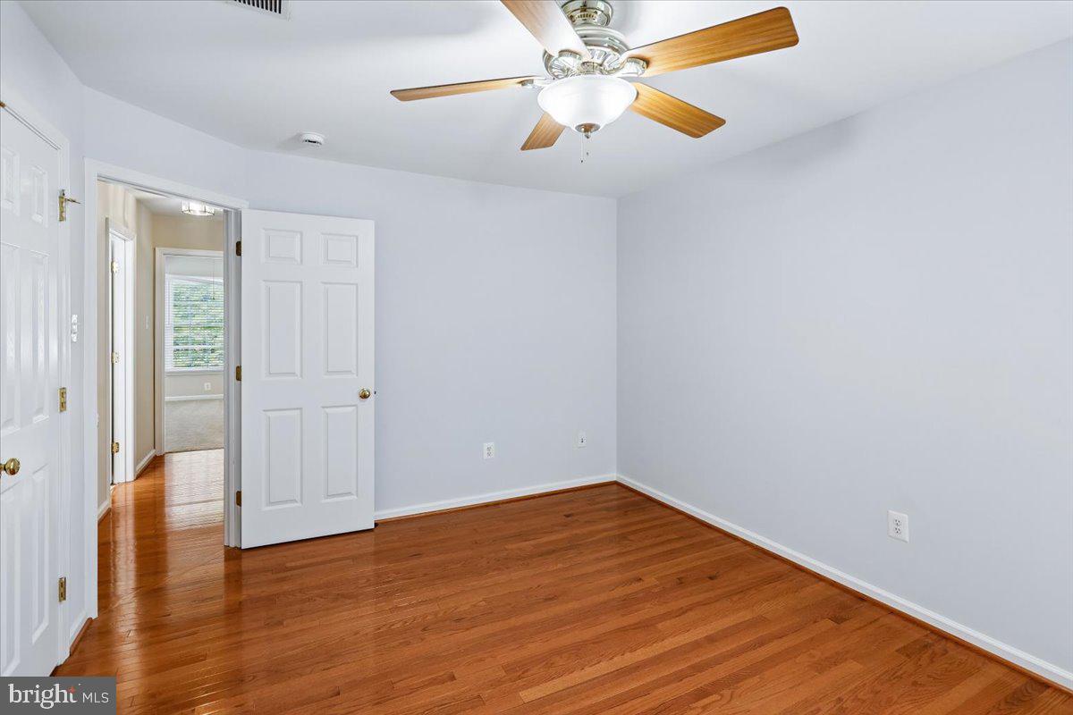 9909 Midsummer Snow Lane Laurel, MD 20723 - Photo 40 of 81 an empty room with wooden floor fan and windows