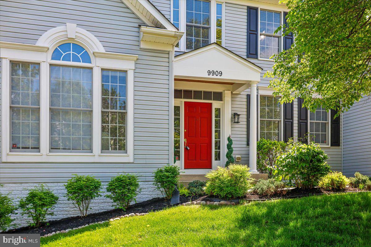 9909 Midsummer Snow Lane Laurel, MD 20723 - Photo 4 of 81 a front view of yellow house with a yard and potted plants