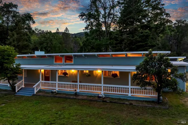 a view of swimming pool with lawn chairs and plants
