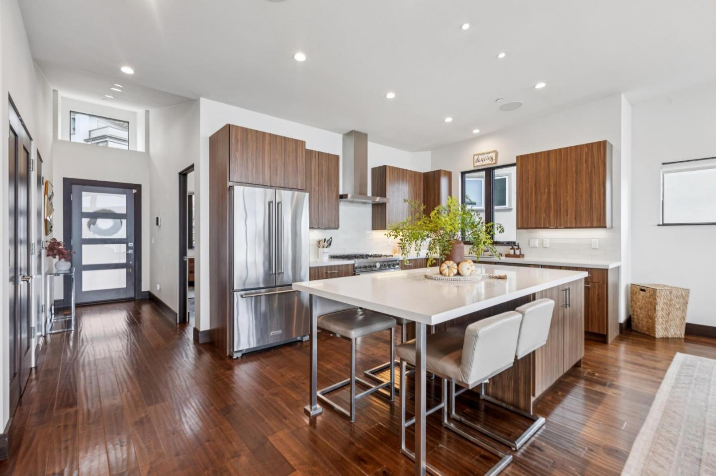 243 Del Monte Road El Granada, CA 94019 - Photo 4 of 66 a kitchen with stainless steel appliances a sink a stove a refrigerator with wooden floor and cabinets