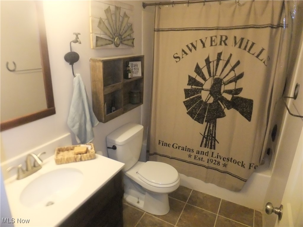 10677 Moss Road Lodi, OH 44254 - Photo 26 of 34 Full bathroom with tile patterned floors, toilet, vanity, and shower / tub combo