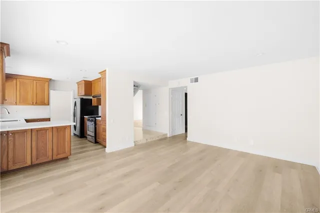 a view of a kitchen with refrigerator stove and wooden cabinets