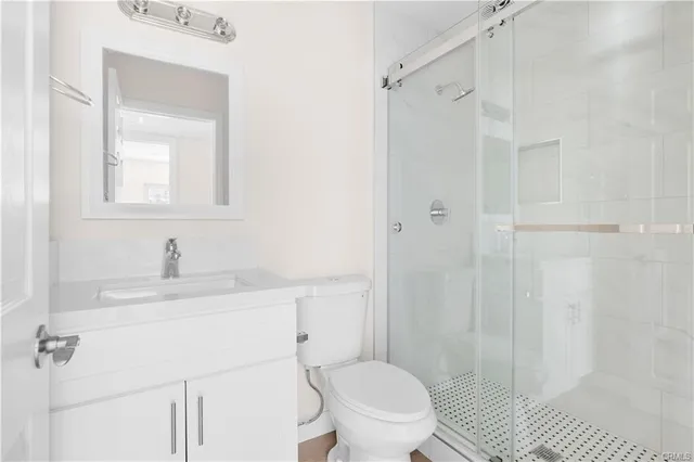 a bathroom with a sink a toilet and shower