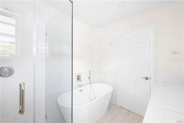 a bathroom with a tub a sink and mirror