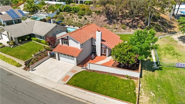 an aerial view of a house with garden space and street view