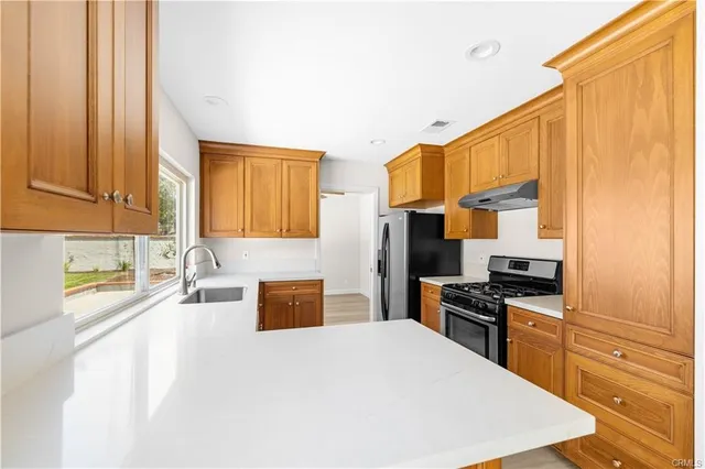a kitchen with stainless steel appliances a sink stove and a refrigerator