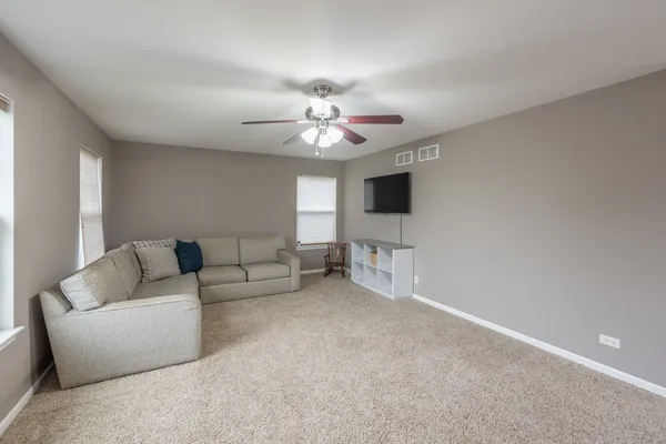 a living room with furniture and a ceiling fan
