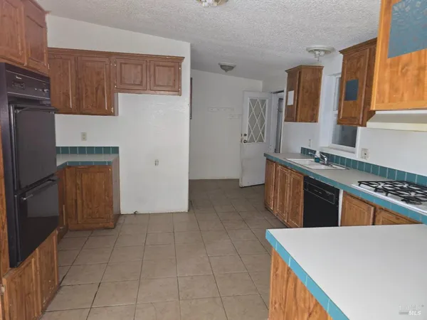 a kitchen with stainless steel appliances granite countertop a stove a refrigerator and a sink