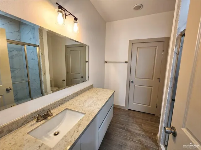 a bathroom with a granite countertop sink and a mirror