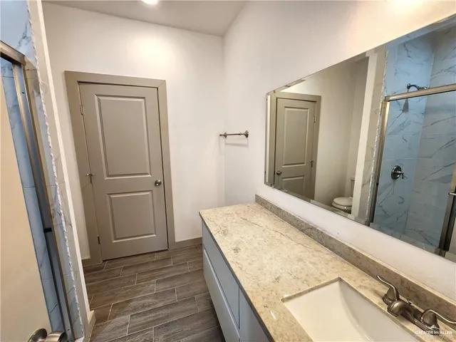 a bathroom with a granite countertop sink and a mirror