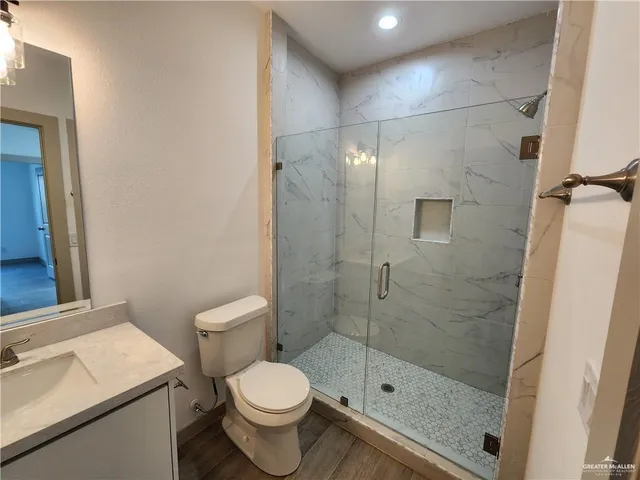 a bathroom with a shower a toilet and a sink