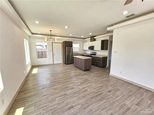 a view of a kitchen with a refrigerator and a stove top oven