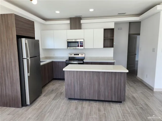 a kitchen with stainless steel appliances a refrigerator and a stove top oven