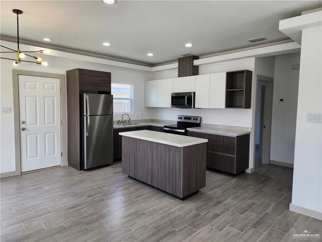a kitchen with a refrigerator and a stove top oven