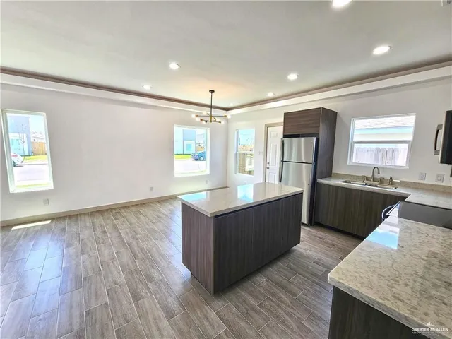 a large kitchen with lots of counter space and wooden floor