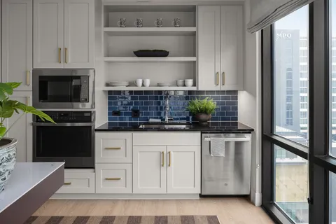 a kitchen with white cabinets and appliances