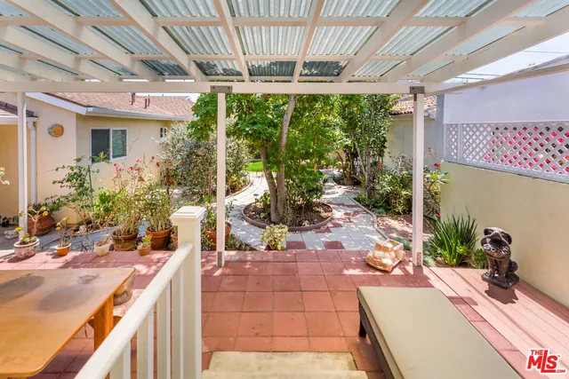 a view of a patio with table and chairs potted plants with wooden floor