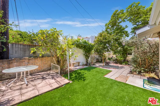 a view of a backyard with table and chairs and potted plants