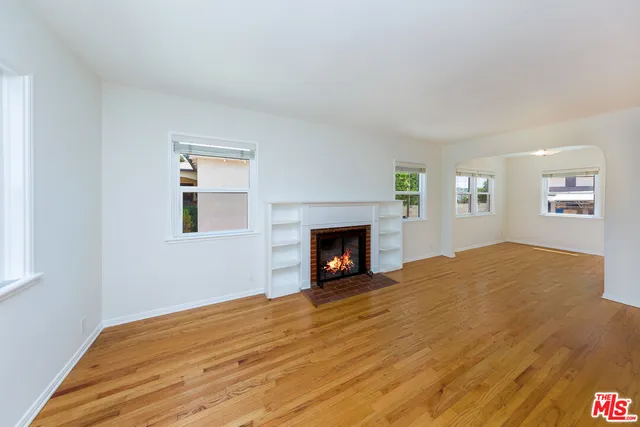 a view of empty room with wooden floor and fireplace