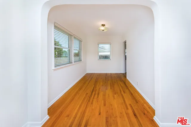 a view of a bedroom with wooden floor and a window