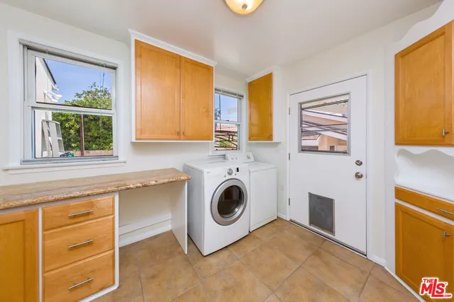 a utility room with stainless steel appliances wooden floor sink and wooden cabinets