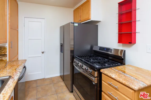 a kitchen with stainless steel appliances granite countertop a stove and a refrigerator