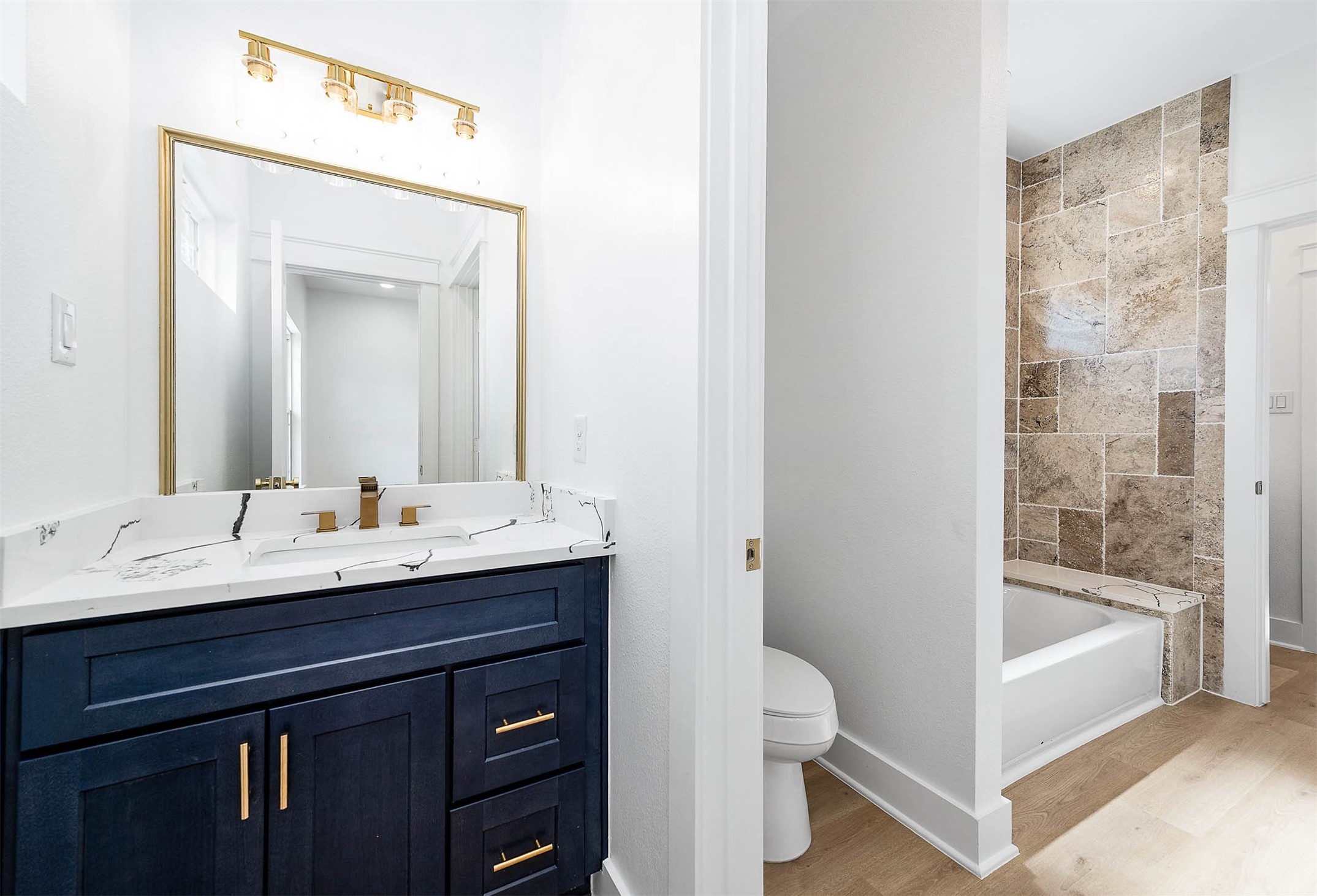 8602 Hoffman Street Houston, TX 77016 - Photo 25 of 30 Adjoining bathroom view from the third bedroom, highlighting the tiled tub/shower and ash blue vanity.