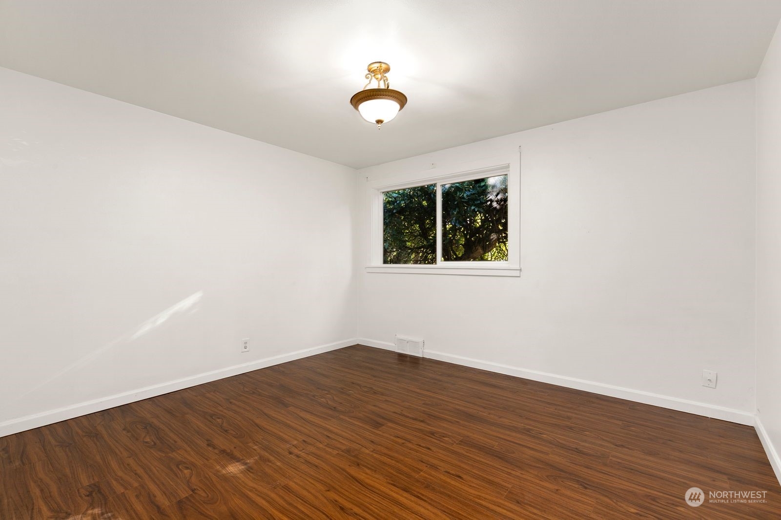 2336 North 135th Street Seattle, WA 98133 - Photo 11 of 17 an empty room with wooden floor and a ceiling fan