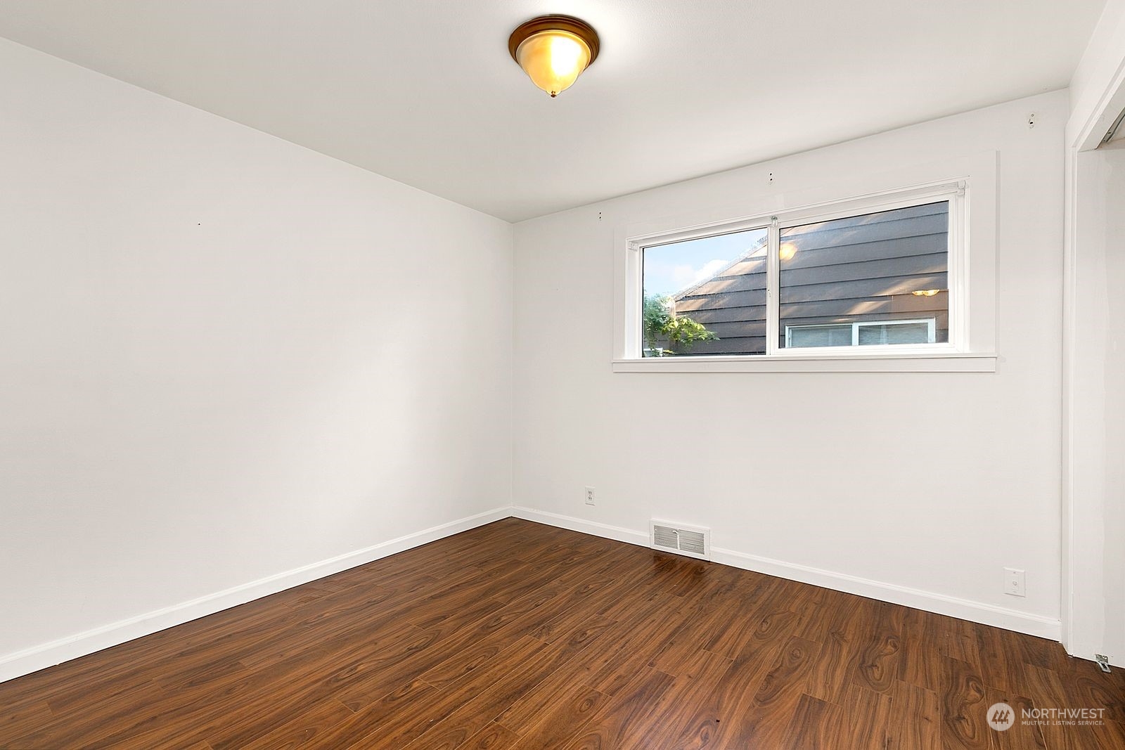 2336 North 135th Street Seattle, WA 98133 - Photo 12 of 17 an empty room with wooden floor and windows
