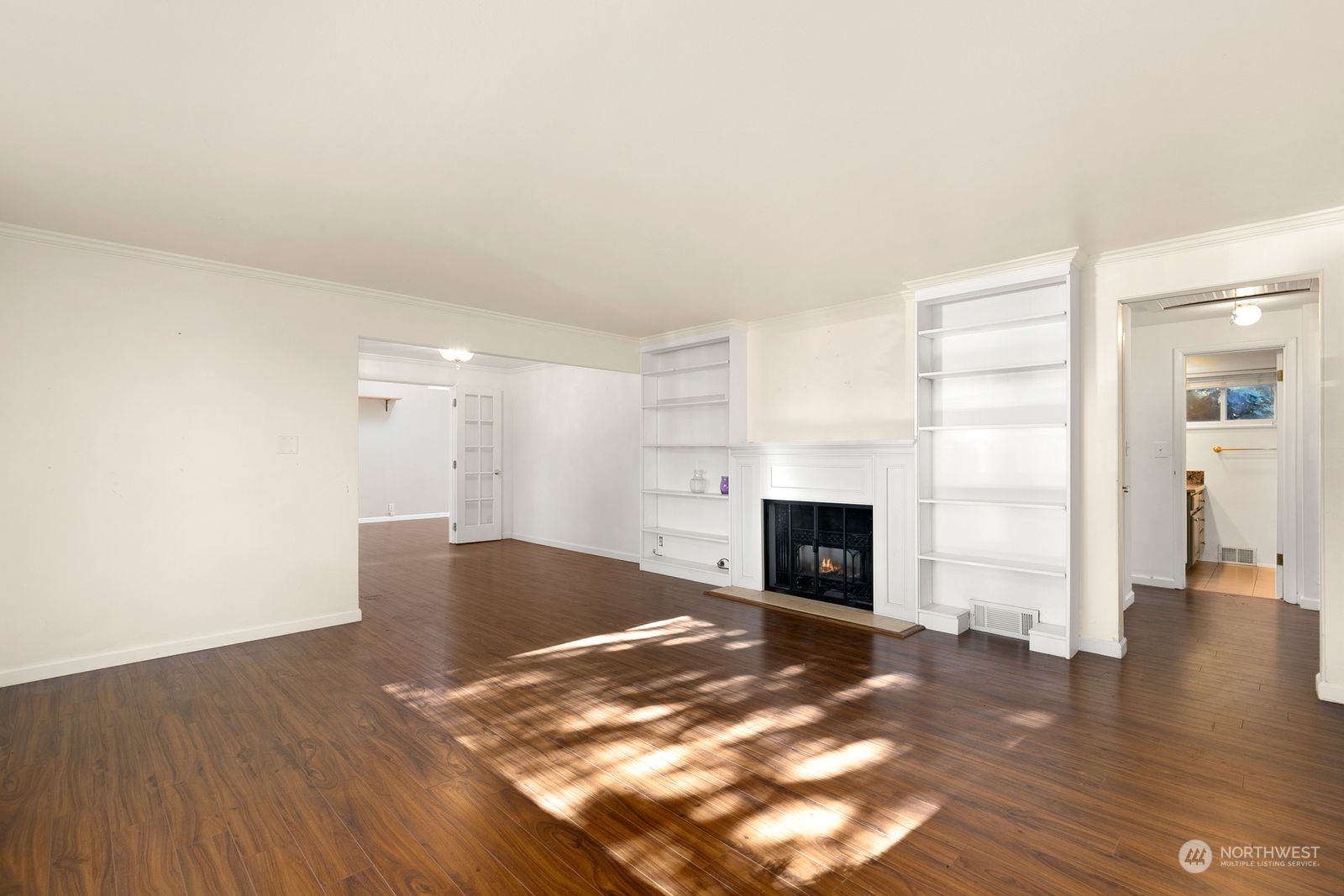 2336 North 135th Street Seattle, WA 98133 - Photo 2 of 17 an empty room with wooden floor fireplace and windows