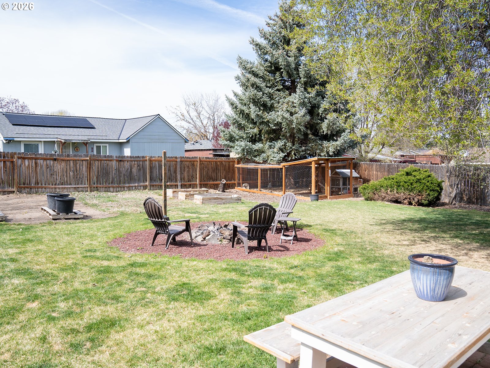 1923 Southwest 20th Street Redmond, OR 97756 - Photo 14 of 17 a view of a backyard with table and chairs potted plants and a fire pit