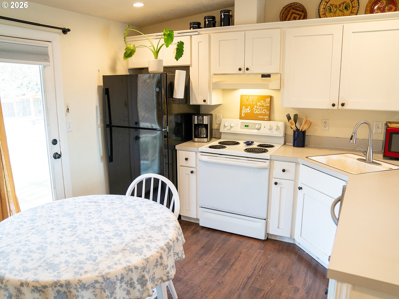 1923 Southwest 20th Street Redmond, OR 97756 - Photo 7 of 17 a kitchen with a refrigerator a sink dishwasher a stove and white cabinets with wooden floor