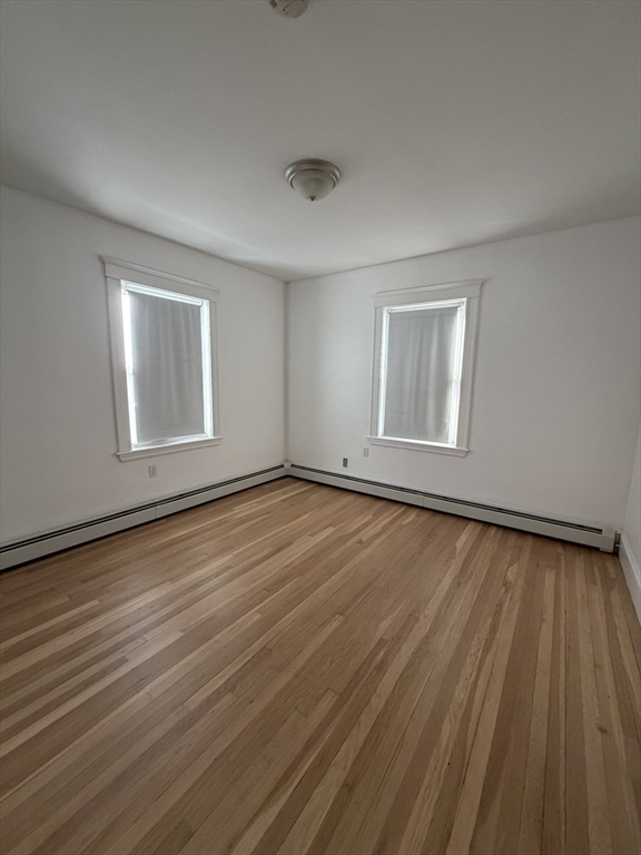 2 Buckingham Road Quincy, MA 02170 - Photo 4 of 10 an empty room with wooden floor and windows