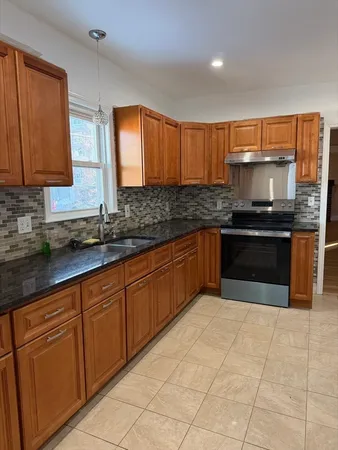 a kitchen with stainless steel appliances granite countertop a stove sink and cabinets
