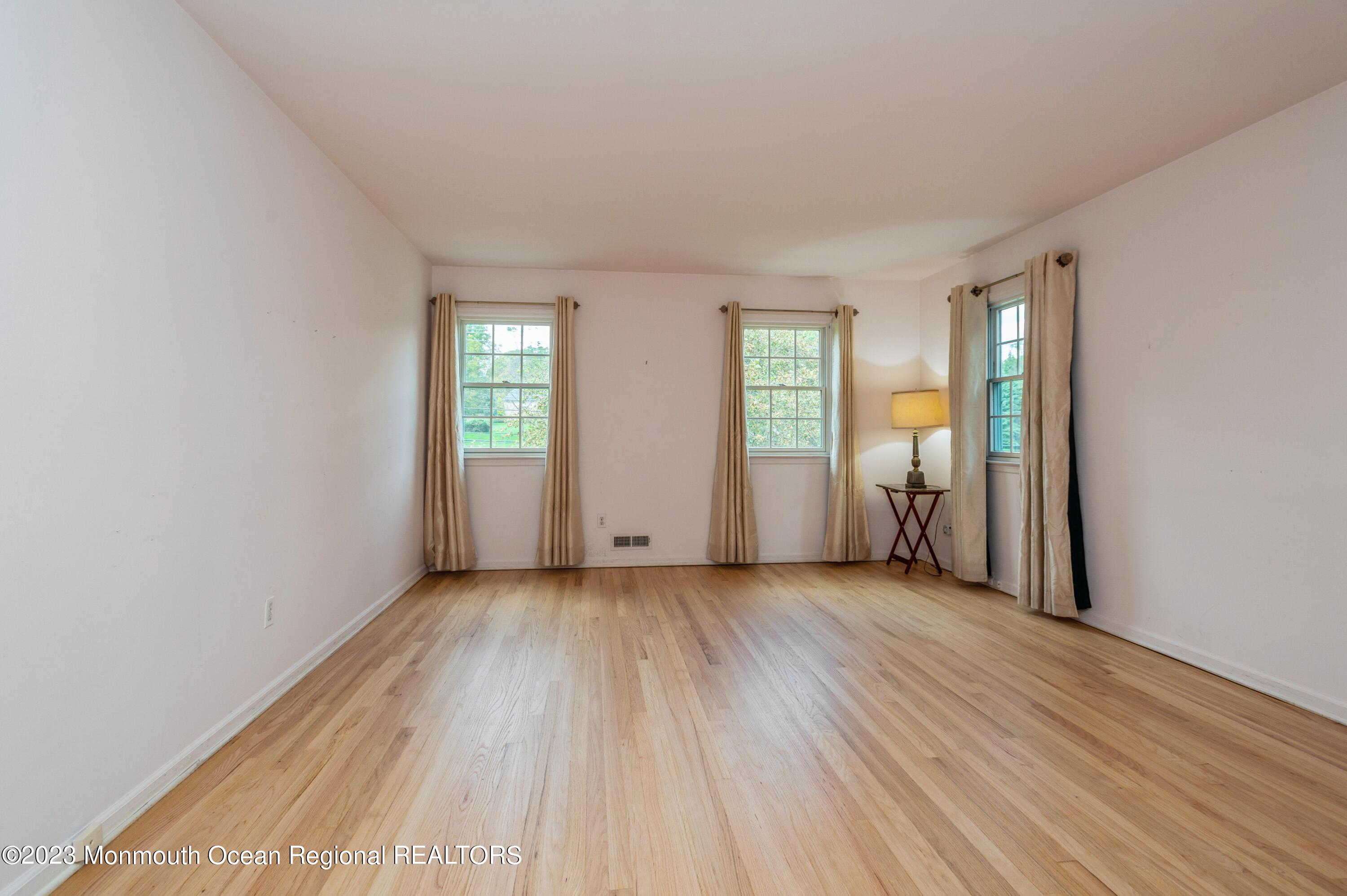 43 McCampbell Road Holmdel, NJ 07733 - Photo 16 of 25 an empty room with wooden floor and windows