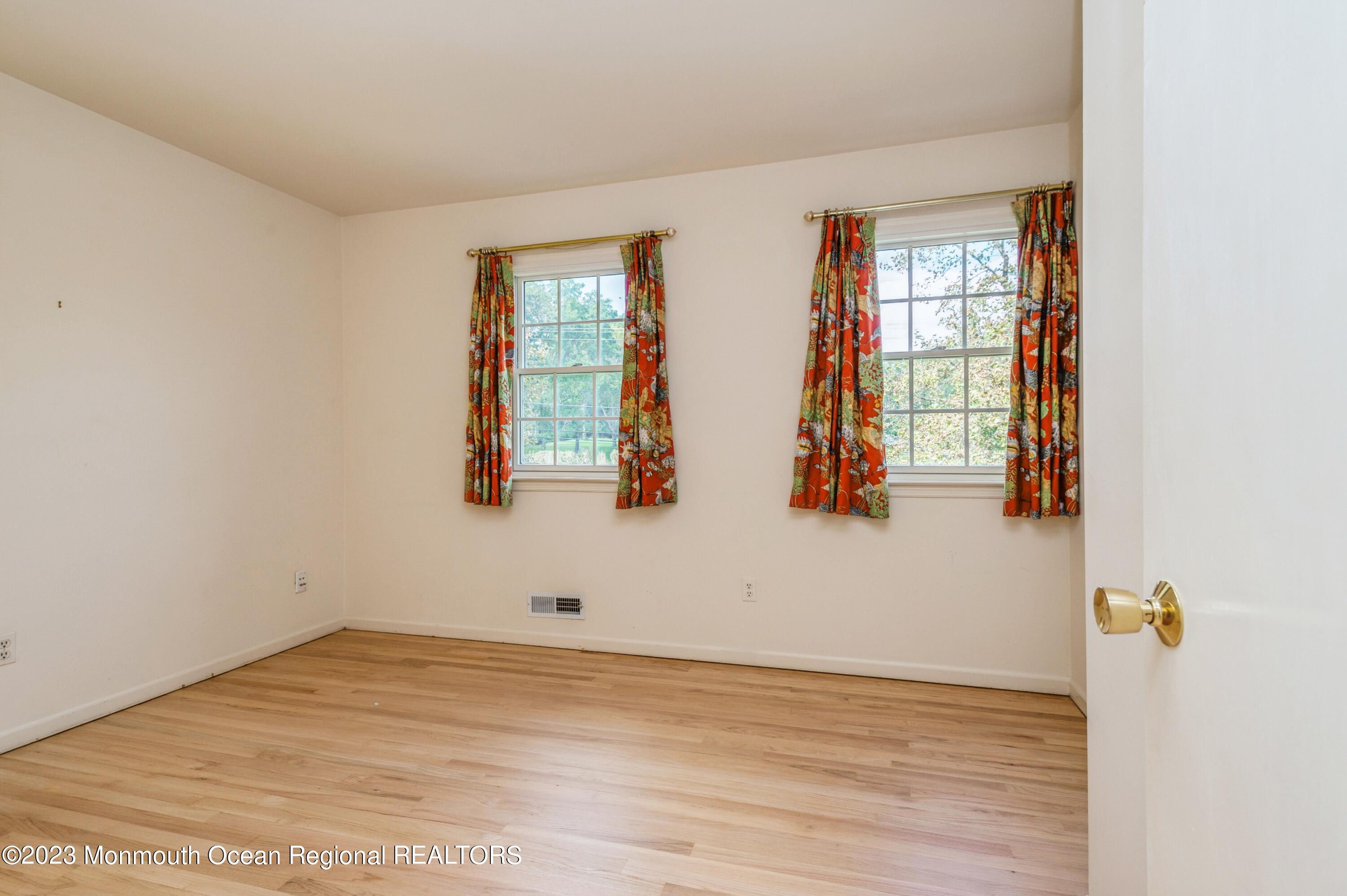 43 McCampbell Road Holmdel, NJ 07733 - Photo 18 of 25 a view of empty room with wooden floor and fan
