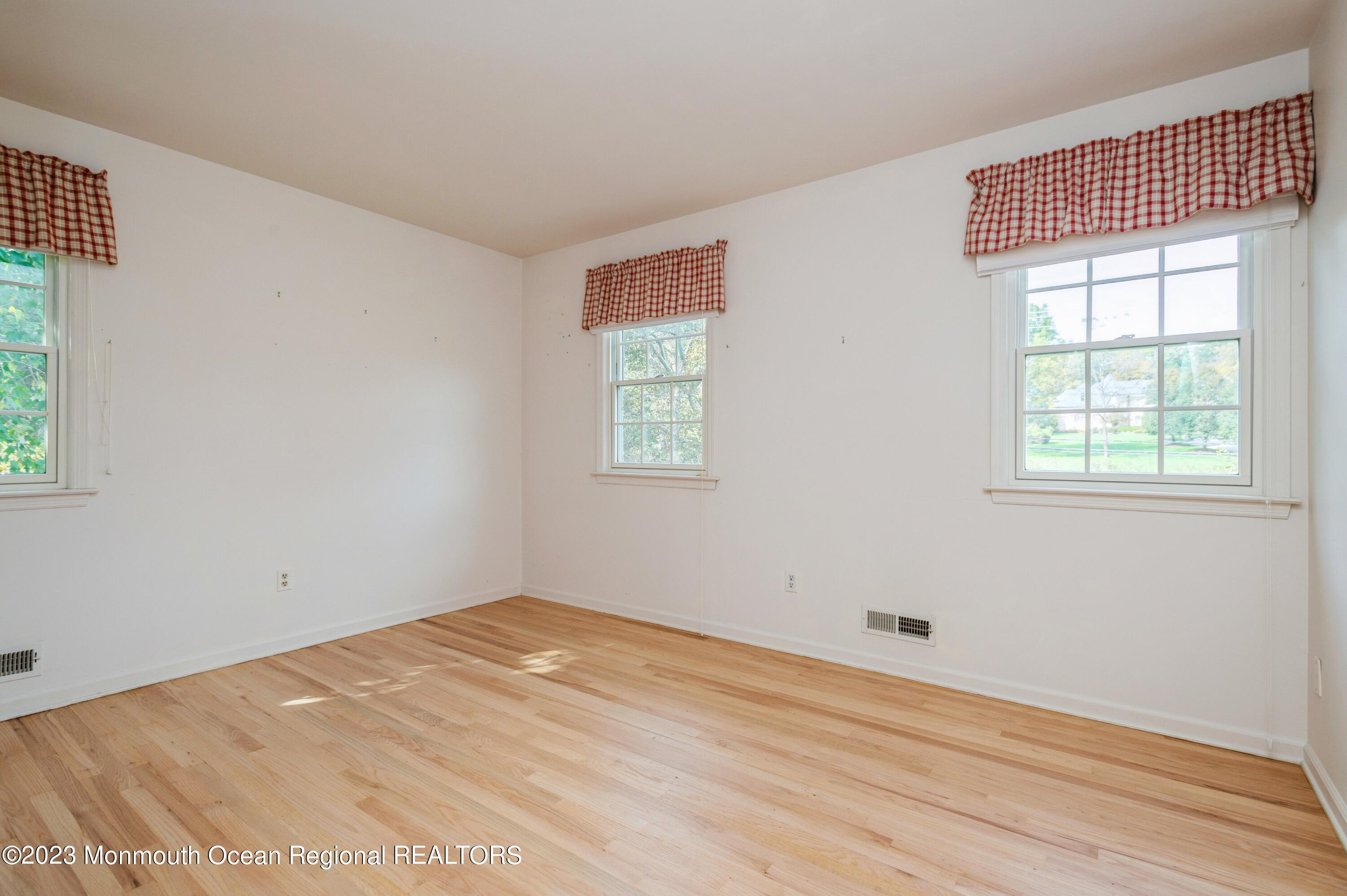 43 McCampbell Road Holmdel, NJ 07733 - Photo 19 of 25 an empty room with wooden floor and windows