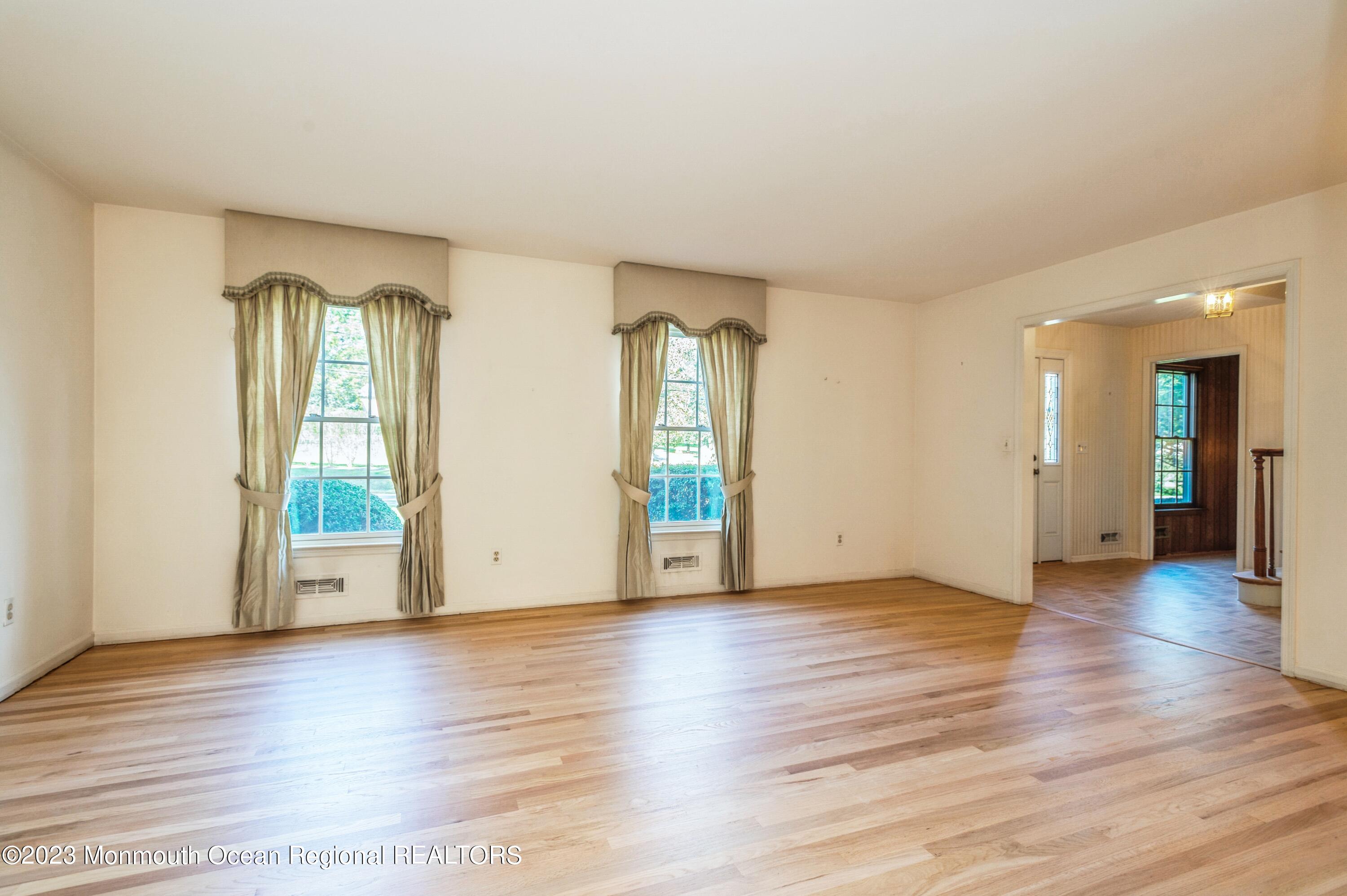 43 McCampbell Road Holmdel, NJ 07733 - Photo 6 of 25 an empty room with wooden floor and windows