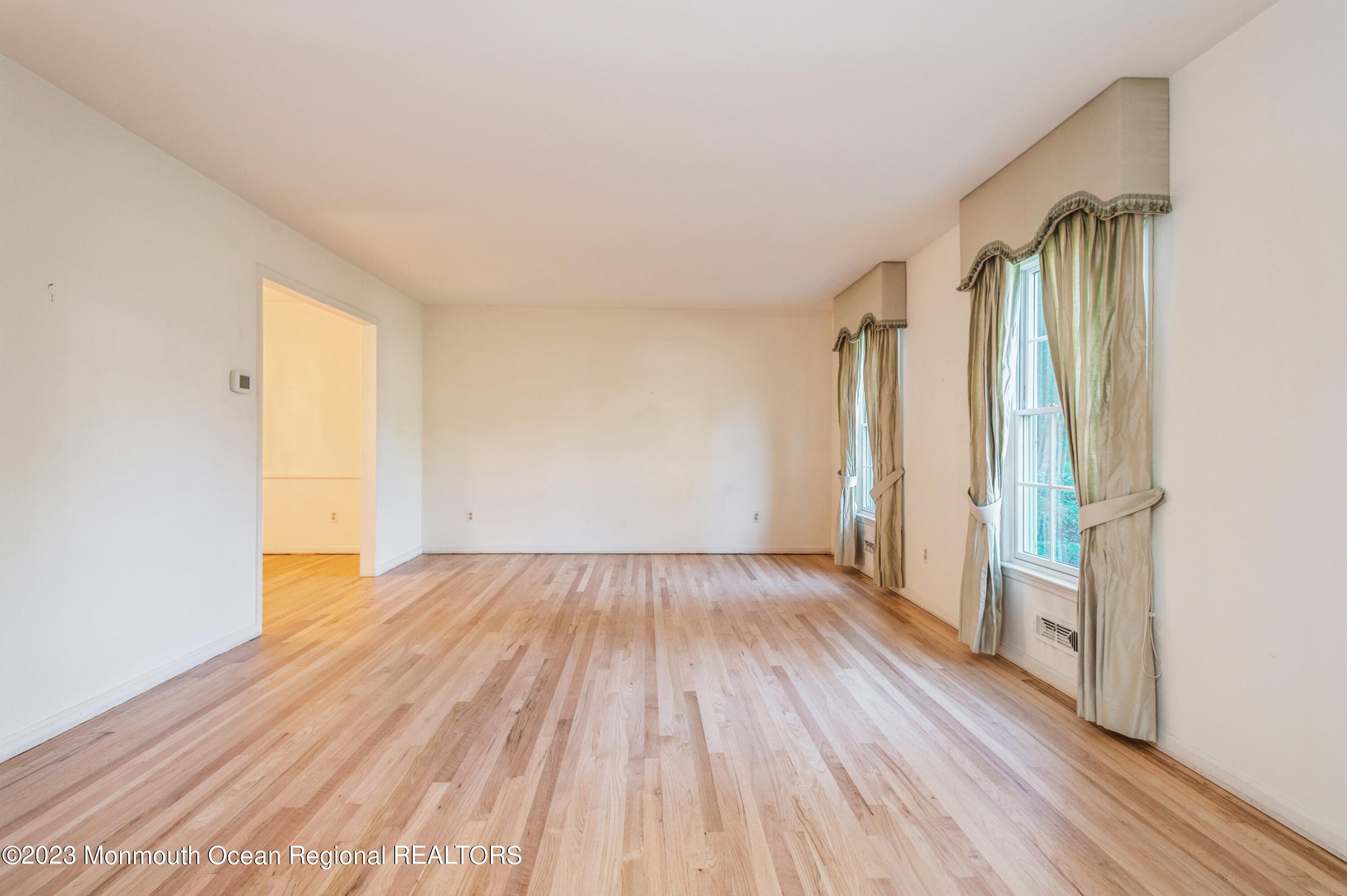 43 McCampbell Road Holmdel, NJ 07733 - Photo 7 of 25 an empty room with wooden floor and a window